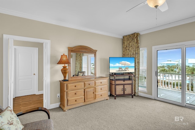 living area with light carpet, a healthy amount of sunlight, and ornamental molding