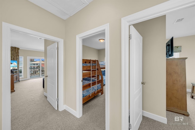 corridor with carpet flooring, visible vents, and baseboards