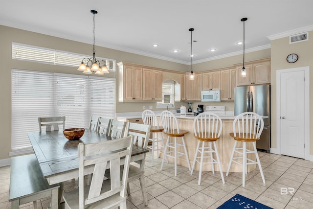 kitchen featuring white microwave, visible vents, light brown cabinets, and freestanding refrigerator