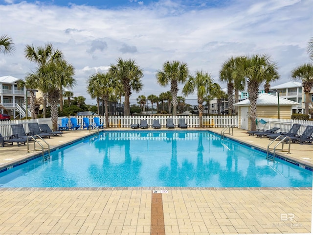 community pool with a patio and fence