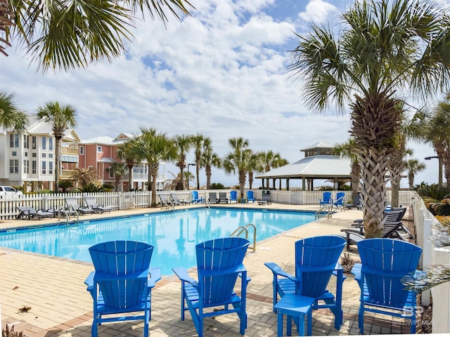 community pool with a patio and fence