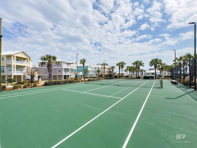 view of sport court with a residential view and fence