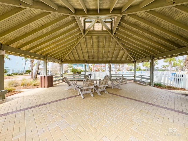 view of patio featuring a gazebo, outdoor dining area, and fence