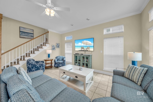 living area featuring tile patterned floors, stairway, baseboards, and crown molding