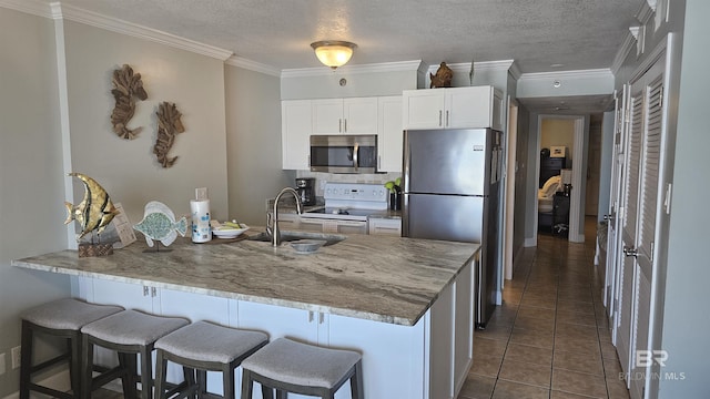 24568 Perdido Beach Blvd Unit 102, Orange Beach, AL 36561 - kitchen with a peninsula, a sink, appliances with stainless steel finishes, and a breakfast bar