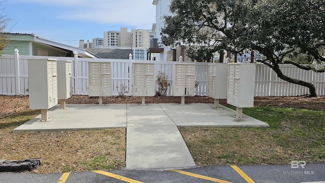 view of community featuring mail area and fence