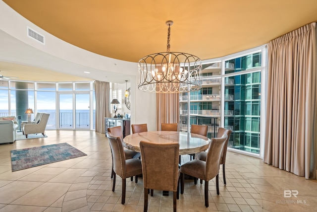 dining room with ceiling fan with notable chandelier, a wall of windows, and light tile patterned floors