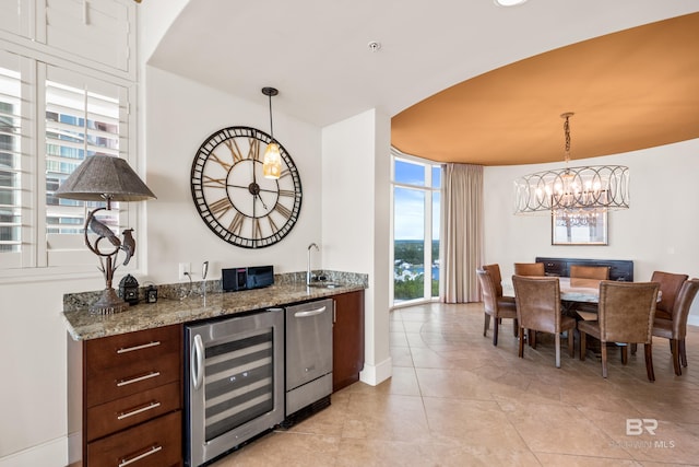 interior space featuring light tile patterned flooring, sink, beverage cooler, decorative light fixtures, and dark stone countertops