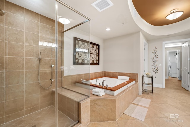 bathroom with independent shower and bath, washer / clothes dryer, and tile patterned floors