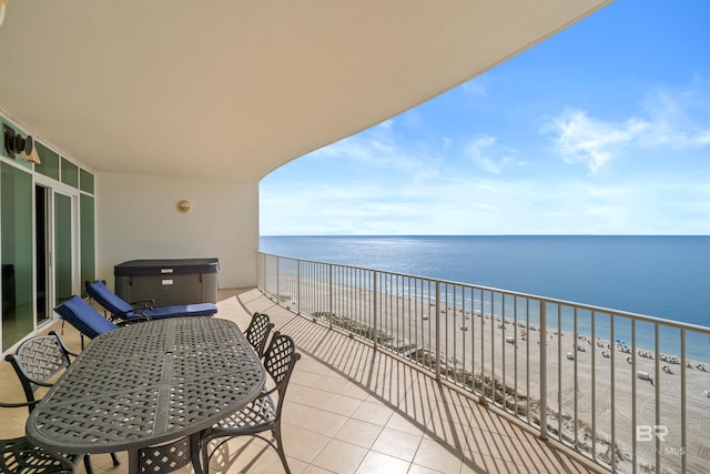 balcony featuring a view of the beach and a water view