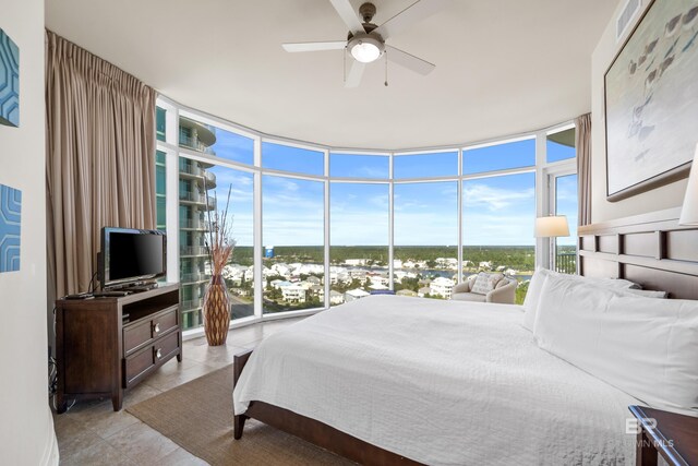 tiled bedroom featuring ceiling fan and floor to ceiling windows