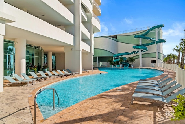 view of swimming pool featuring a water slide and a patio area