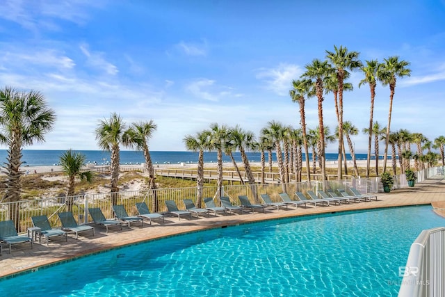 view of swimming pool featuring a patio and a water view