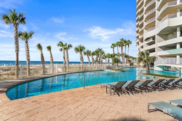 view of pool featuring a water view and a view of the beach