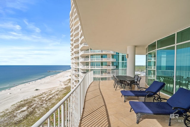 balcony featuring a view of the beach and a water view