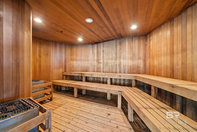 view of sauna / steam room with wood ceiling, wooden walls, and hardwood / wood-style flooring