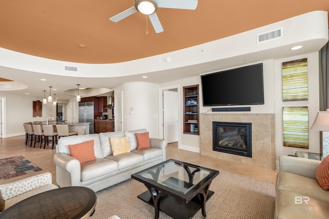 living room featuring ceiling fan and a fireplace