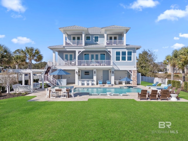 4029 Landfall Dr, Pensacola, FL 32507 - rear view of house featuring a standing seam roof, fence, metal roof, a balcony, and a patio area