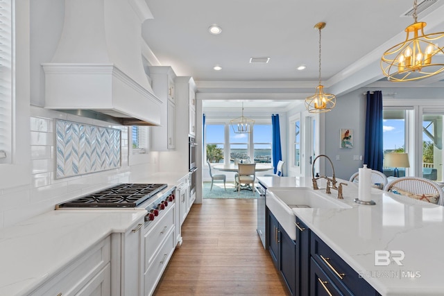4029 Landfall Dr, Pensacola, FL 32507 - kitchen with custom range hood, blue cabinets, a sink, white cabinets, and a notable chandelier