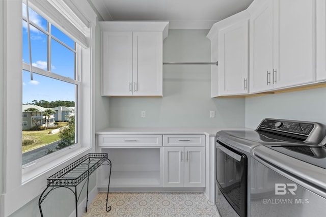 4029 Landfall Dr, Pensacola, FL 32507 - laundry area with light tile patterned flooring, cabinet space, and washer and dryer
