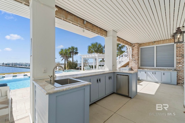 4029 Landfall Dr, Pensacola, FL 32507 - view of patio / terrace with a water view, exterior kitchen, a sink, and a pergola