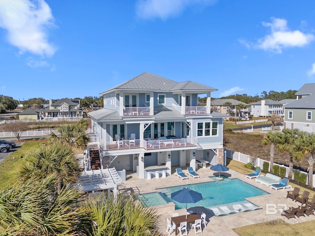 4029 Landfall Dr, Pensacola, FL 32507 - rear view of house featuring a patio, metal roof, a fenced backyard, a balcony, and a fenced in pool