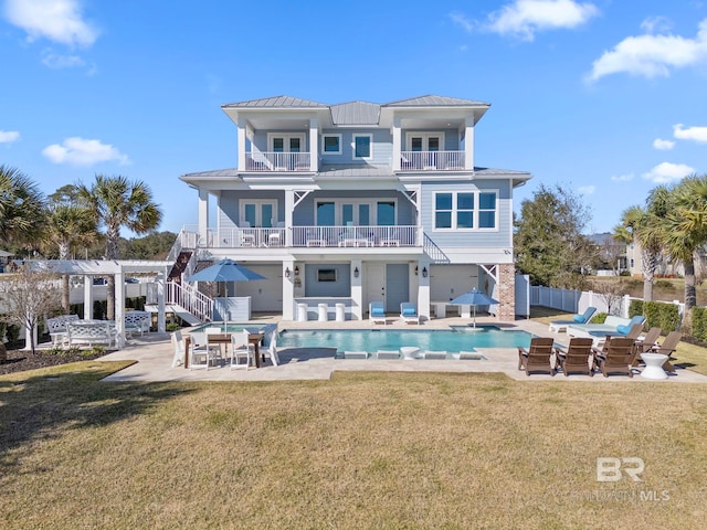 4029 Landfall Dr, Pensacola, FL 32507 - back of house featuring a standing seam roof, fence, a patio, metal roof, and a balcony