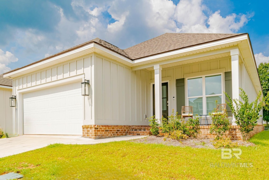 single story home featuring a garage, covered porch, and a front yard