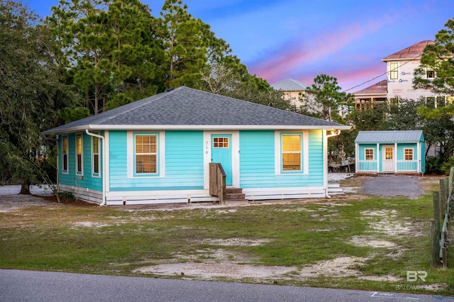 710 Gulf Way Dr, Gulf Shores, AL 36542 - view of front of property with an outbuilding, a lawn, and a shingled roof