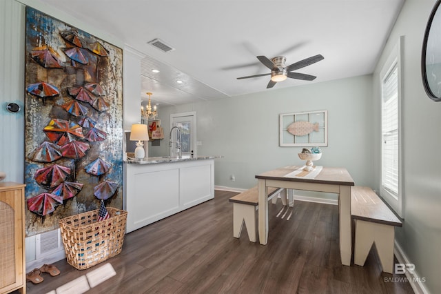 dining room featuring visible vents, a healthy amount of sunlight, dark wood finished floors, and ceiling fan with notable chandelier