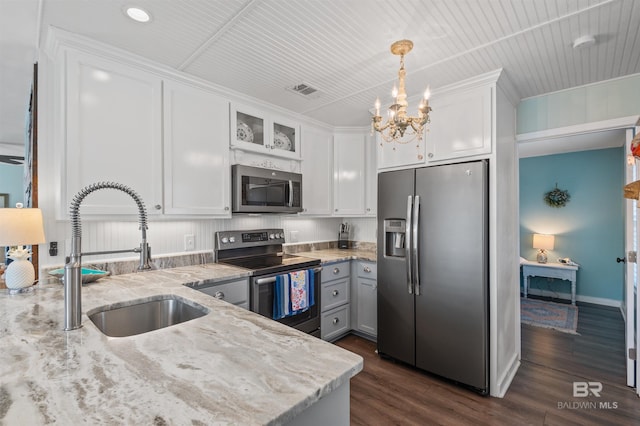 kitchen with a notable chandelier, a sink, stainless steel appliances, white cabinets, and light stone countertops