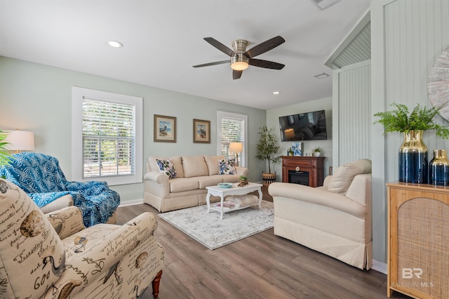 living room featuring dark wood-type flooring, recessed lighting, a fireplace, and ceiling fan