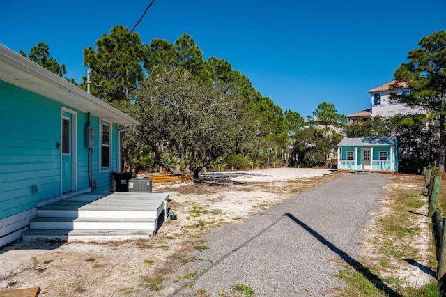 view of yard featuring central air condition unit and an outbuilding