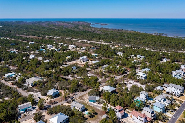 drone / aerial view featuring a wooded view and a water view