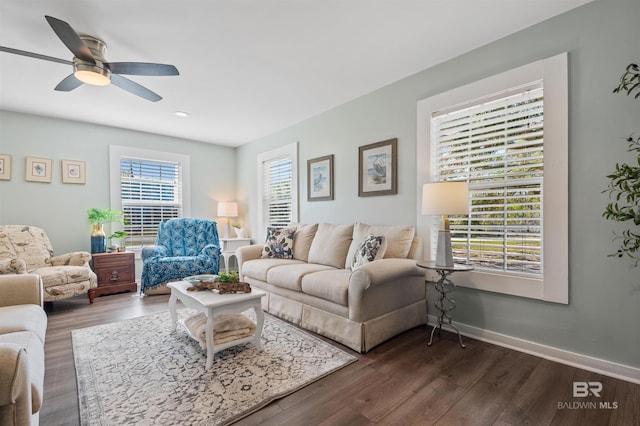 living area featuring ceiling fan, dark wood-type flooring, and baseboards