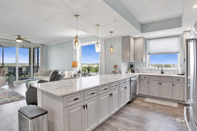 608 Lost Key Dr Unit 705C, Pensacola, FL 32507 - kitchen with stainless steel appliances, a peninsula, a sink, a ceiling fan, and light stone counters