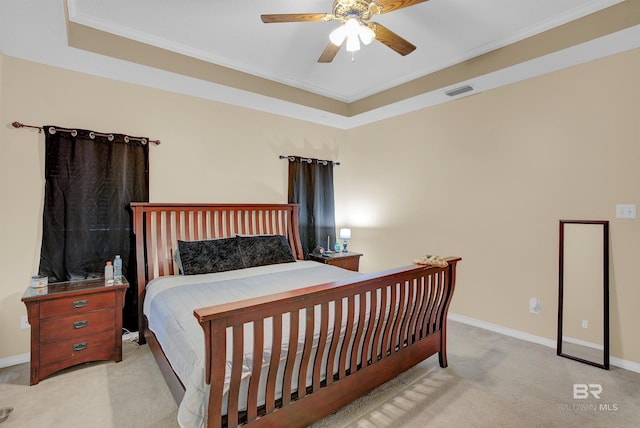 bedroom with crown molding, light carpet, ceiling fan, and a raised ceiling