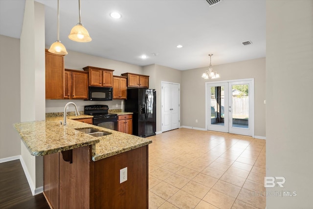 kitchen featuring black appliances, kitchen peninsula, hanging light fixtures, and an inviting chandelier