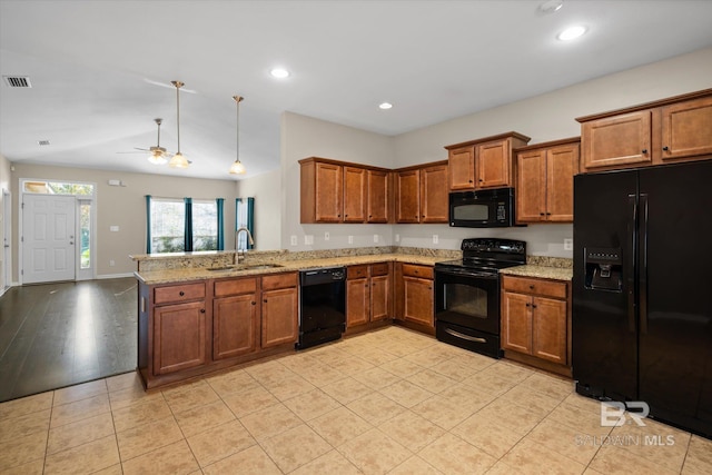 kitchen with black appliances, sink, ceiling fan, light stone counters, and kitchen peninsula