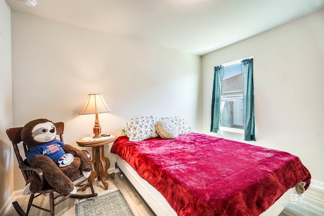 bedroom with baseboards and wood finished floors