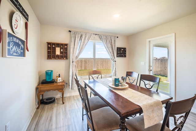 dining room featuring light wood finished floors and baseboards