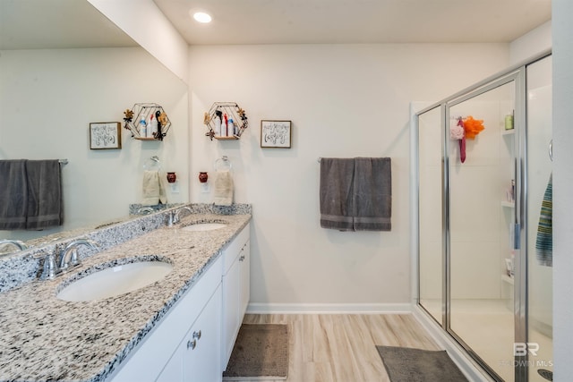 full bath with a sink, a shower stall, and wood finished floors