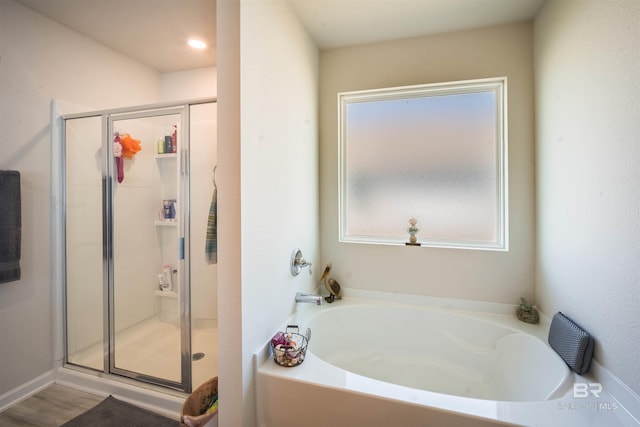 bathroom featuring a stall shower and a garden tub