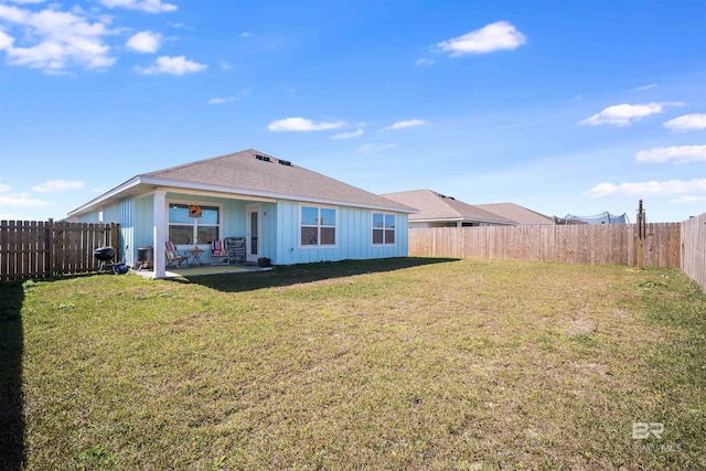 rear view of property with a lawn, a patio area, and a fenced backyard