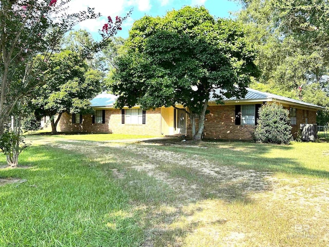 view of front of house with a front lawn, brick siding, and driveway