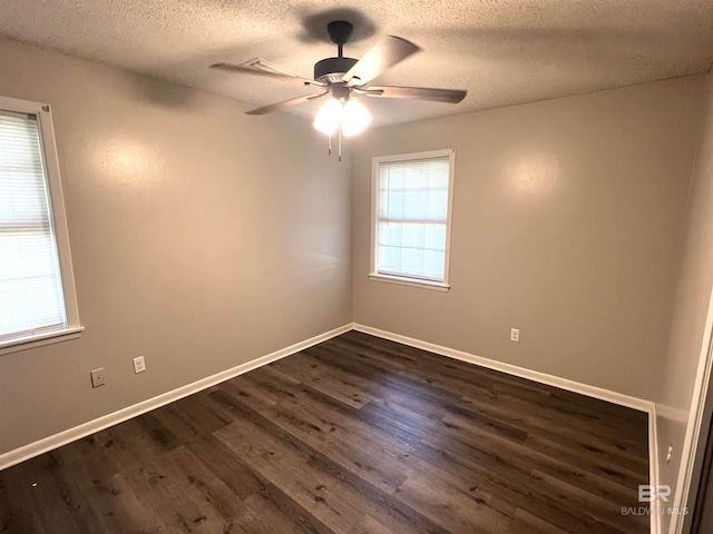 unfurnished room with dark wood-style floors, ceiling fan, a textured ceiling, and baseboards