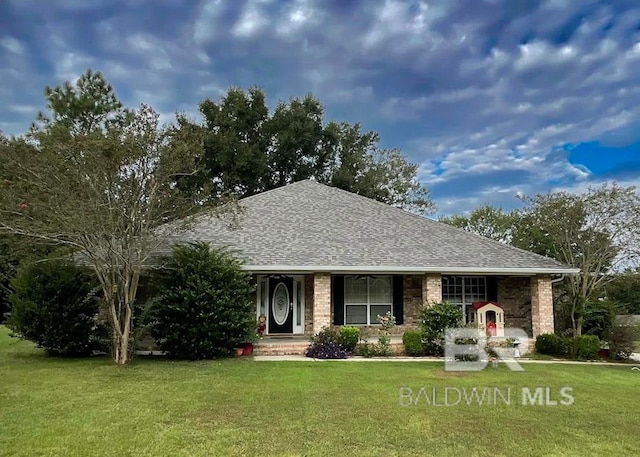 single story home with brick siding, roof with shingles, and a front yard