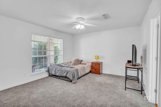 bedroom featuring carpet, visible vents, a ceiling fan, a textured ceiling, and baseboards