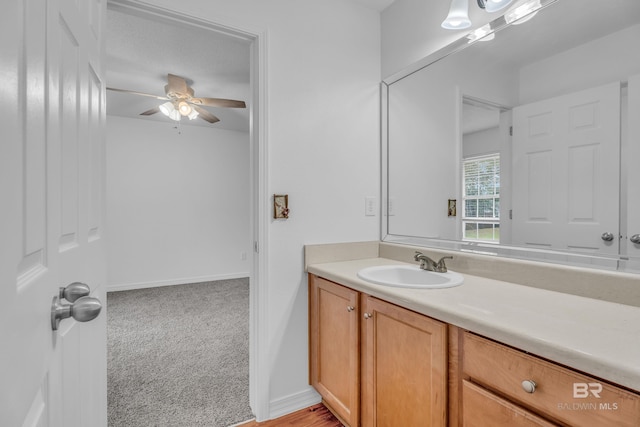 bathroom with a ceiling fan, vanity, and baseboards