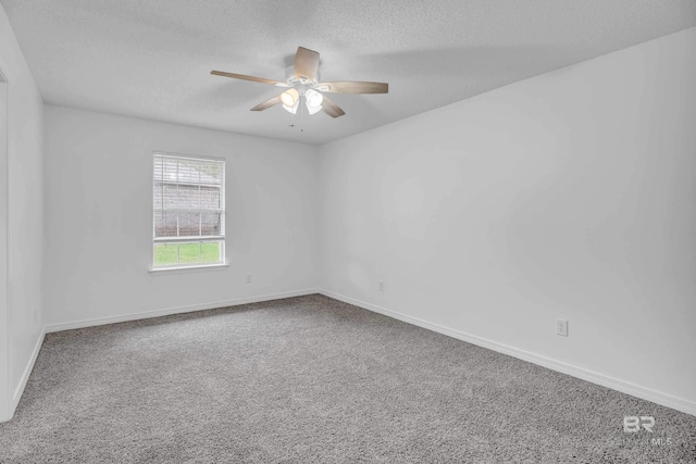 carpeted empty room featuring a ceiling fan, a textured ceiling, and baseboards